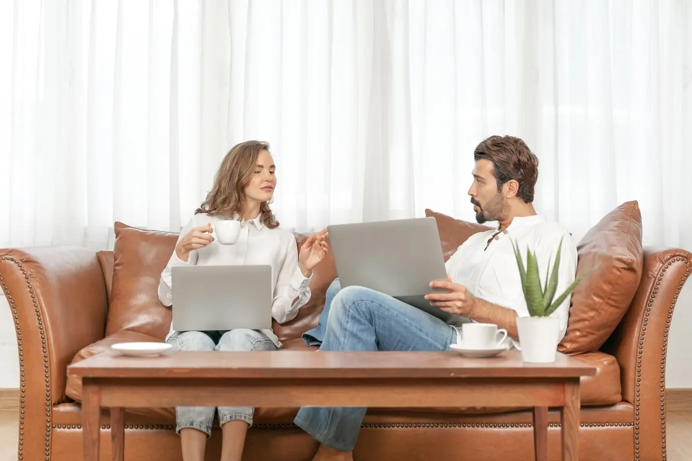 Portrait of a businessman and a businesswoman using a laptop computer in a home office.
